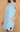 Light blue dress with floral details on a beige background