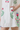 White dress with colorful floral patterns on a plain background
