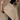 A woman wearing a beige textured knit poncho draped over her shoulders, paired with dark blue jeans, posed against a neutral beige studio background.