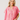 Woman wearing a pink and red striped shirt against a plain background