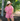Woman wearing a pink striped outfit with a wide-brimmed hat in a tropical setting