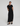 Woman wearing a black dress with a tie waist on a white background