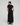 Woman wearing a black dress with a slit on a white background
