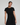Woman wearing a black dress against a plain background