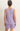 Person wearing a light purple sleeveless top and shorts set on a beige background
