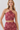 A woman modeling a two-piece halter crop top and matching high-waisted skirt set in a dusty rose and pink paisley pattern, against a light gray studio background.