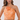 A woman modeling a peach and cream patterned two-piece set featuring a halter crop top with a large fabric flower accent at the neckline and matching high-waisted bottoms.