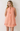 WOMAN WEARING AN ORANGE GINGHAM SHIFT DRESS.