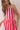 Woman wearing a red and white striped dress against a plain background