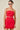 Woman wearing a red strapless dress with star patterns on a beige background