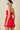 Woman wearing a red dress with star patterns on a beige background