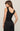 Woman wearing a black dress with white polka dots on a beige background