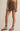 Brown skirt worn by a person on a beige background