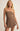 Woman wearing a brown strapless dress against a plain background