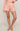 Person wearing pink textured pajama set on a plain background