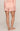 Person wearing a pink polka dot pajama set on a plain background