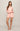 Woman wearing a pink pajama set on a plain background