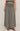 Person wearing a black and white checkered skirt on a beige background