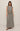 Woman wearing a checkered sleeveless top and long skirt on a beige background