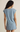 Woman wearing a light blue dress against a beige background