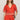 Woman wearing a red embroidered outfit on a plain background