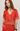 Woman wearing a red outfit with white patterns on a plain background