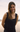Woman wearing a black sleeveless top with a scenic background