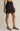 Black skirt with lace detailing worn by a person on a neutral background