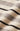 Close-up of a knit fabric with horizontal stripes in cream, light gray, and black.