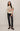 Woman wearing a striped sweater and black pants on a plain background