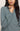 Person wearing a teal sweater with a neutral background