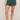 Person wearing green shorts on a beige background