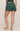 Person wearing green shorts on a beige background