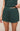 Green shorts worn by a person on a beige background