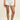 Person wearing a pair of shorts with a martini and bow pattern on a plain background