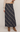 A navy blue plaid maxi skirt with a diagonal tartan pattern in white and gray, styled with a beige knit sweater and brown suede ankle boots against a light gray studio background.
