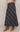 A navy blue plaid maxi skirt with white and gray stripes, styled with a beige sweater and tan pointed-toe heeled ankle boots against a light beige studio background.