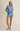 Woman wearing a blue ribbed pajama set on a beige background