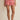 Red and white striped shorts worn by a person on a beige background