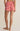 Person wearing red and white striped shorts on a beige background