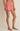 Person wearing red and white striped shorts on a beige background