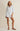 Woman wearing a striped shirt and shorts set on a beige background