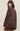 Woman wearing a brown suede jacket on a beige background