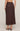 Brown polka dot skirt worn by a person on a beige background