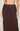 Brown skirt with white polka dots worn by a person on a neutral background