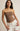 Woman wearing a brown strapless top and white shorts on a beige background
