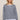 Woman wearing a striped sweater and shorts on a beige background