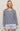 Woman wearing a striped sweater and shorts on a beige background