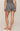 Person wearing a patterned romper on a beige background