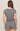 Woman wearing a patterned romper on a beige background